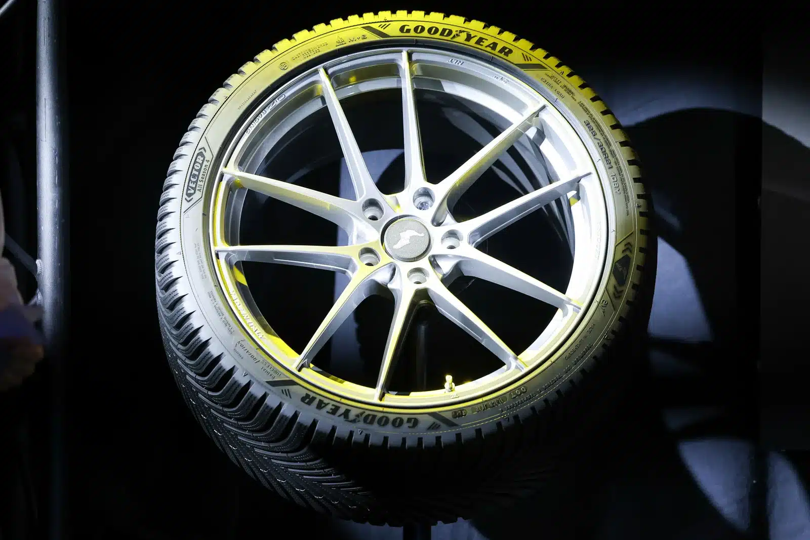 Nieuwe Goodyear Vector All Season 4 vierseizoenenband op lichtmetalen velg, belicht tegen donkere achtergrond
